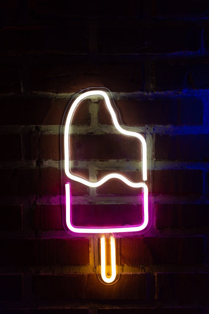 Neon ice cream sign glowing against a brick wall, creating a vibrant atmosphere.